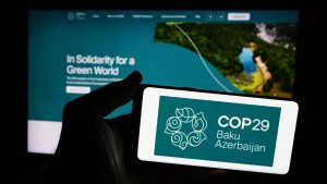 Stuttgart, Germany - 06-14-2024: Person holding smartphone with logo of United Nations Climate Change Conference 2024 COP29 in front of website. Focus on phone display.